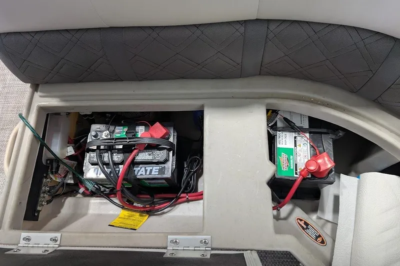 Slide: The Image of 2018 Lund LX220 Pontoon battery compartment with dual batteries and wiring. - 26