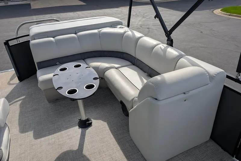 Slide: The Image of 2018 Lund LX220 Pontoon interior with plush seating and round table. - 36