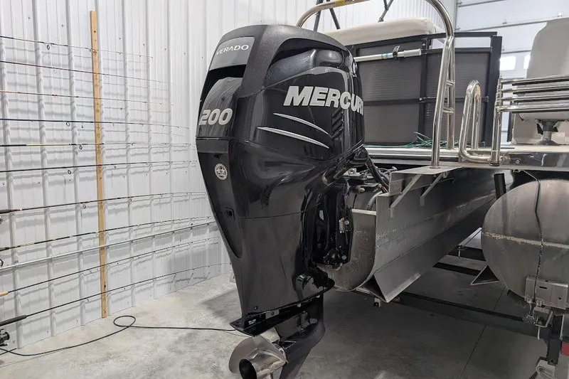 Slide: The Image of 2018 Lund LX220 Pontoon with Mercury 200 outboard motor in a garage setting. - 4