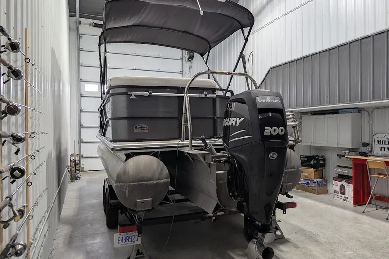 Slide: The Image of 2018 Lund LX220 Pontoon with Mercury 200 engine in a storage facility. - 5