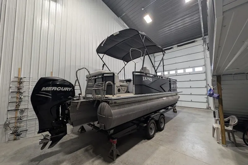 Slide: The Image of 2018 Lund LX220 Pontoon boat with Mercury engine in a spacious garage. - 6