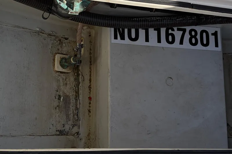 Slide: The Image of Interior view of a 2005 Pursuit 3370 Offshore boat, showing a pipe and identification number. - 10