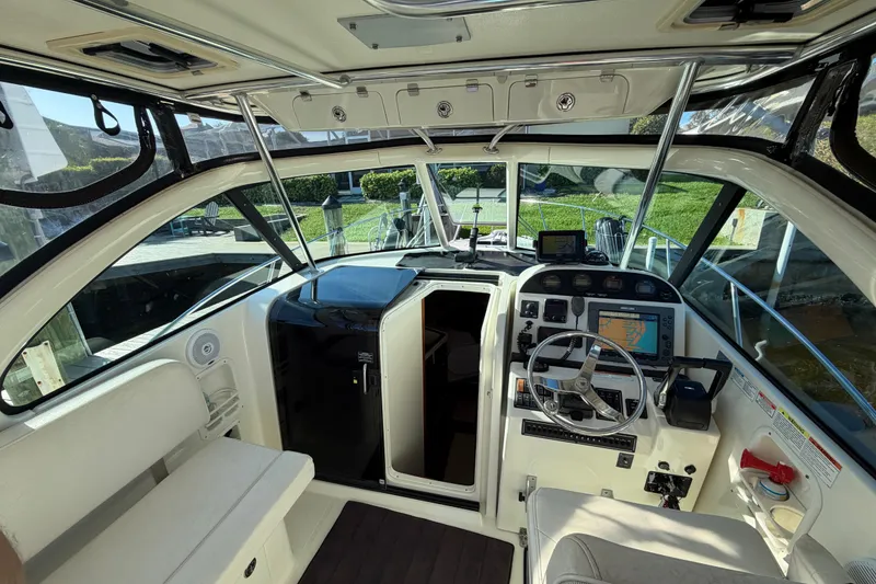 Slide: The Image of 2005 Pursuit 3370 Offshore boat interior with steering wheel, navigation equipment, and seating. - 13