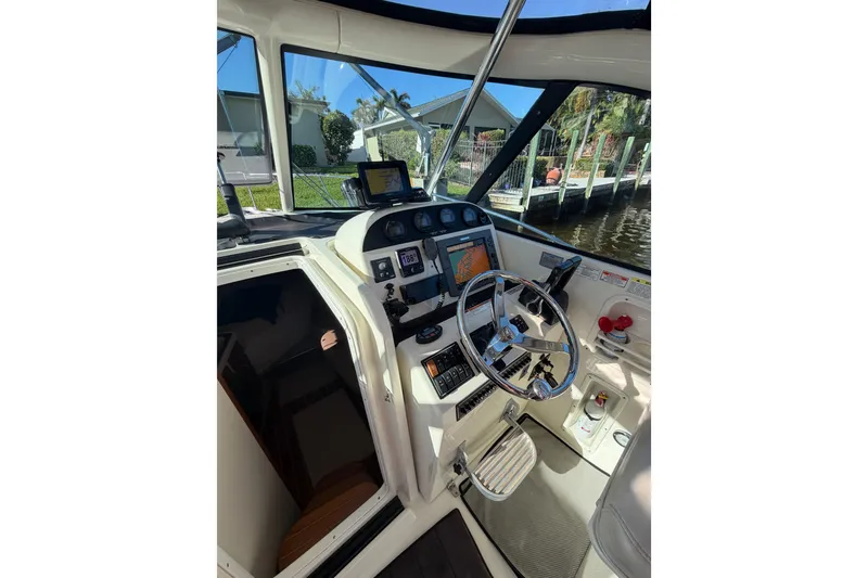 Slide: The Image of 2005 Pursuit 3370 Offshore boat helm with navigation equipment and steering wheel. - 14