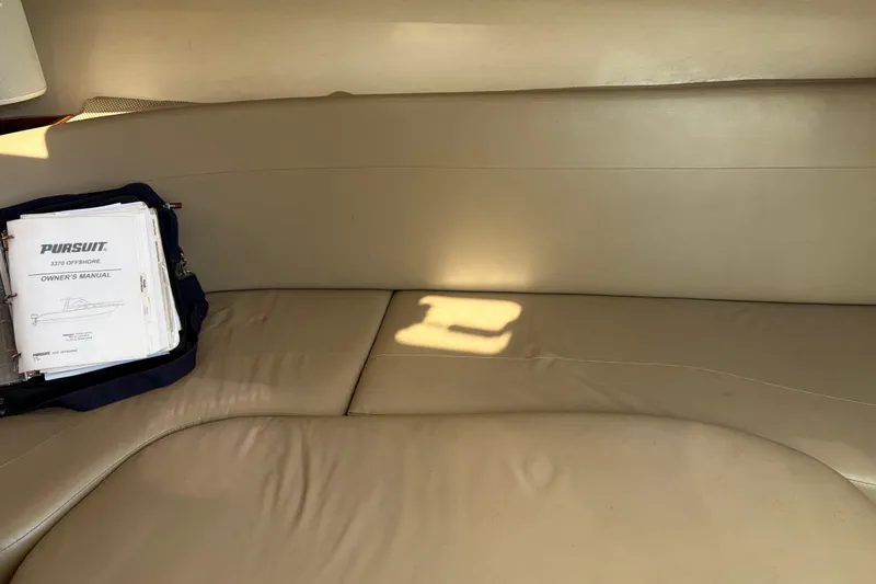 Slide: The Image of 2005 Pursuit 3370 Offshore owner's manual on beige boat seating. - 18