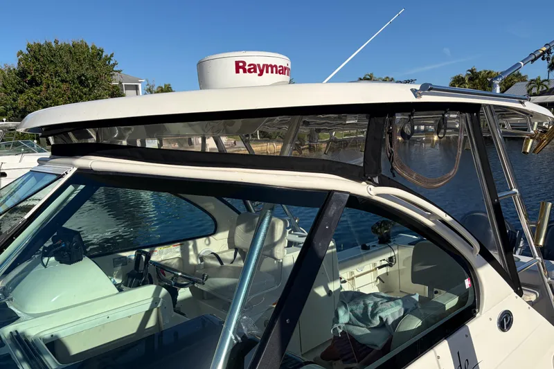 Slide: The Image of 2005 Pursuit 3370 Offshore boat with Raymarine radar, docked by the water. - 2