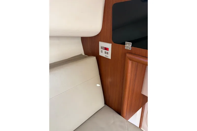 Slide: The Image of Interior of a 2005 Pursuit 3370 Offshore boat, featuring a control panel and cushioned seating. - 21