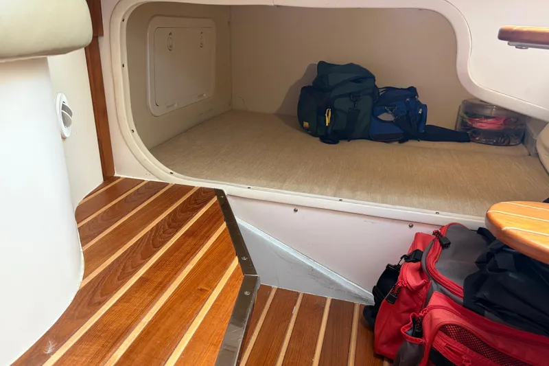 Slide: The Image of 2005 Pursuit 3370 Offshore cabin interior with wooden steps and storage area. - 22