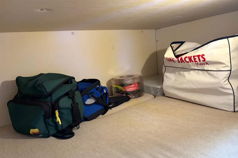 Slide: The Image of Storage area in a 2005 Pursuit 3370 Offshore boat with bags and life jackets. - 23