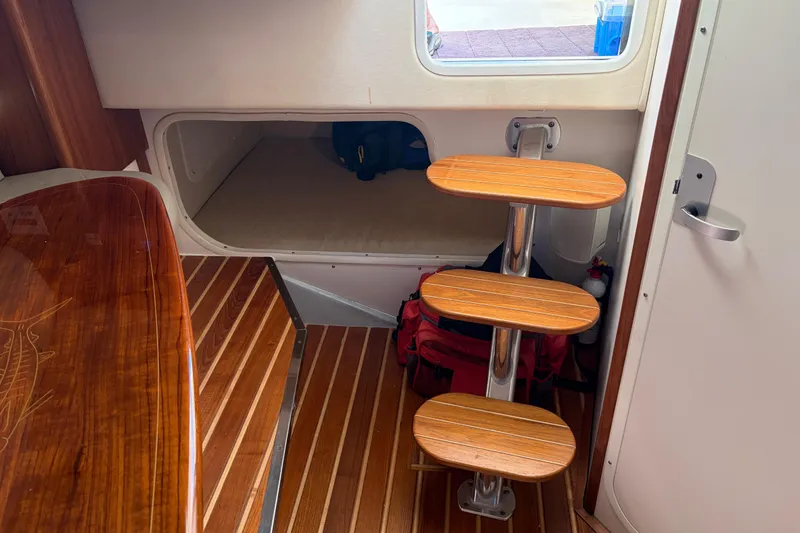 Slide: The Image of Interior of 2005 Pursuit 3370 Offshore boat with wooden steps and storage area. - 24