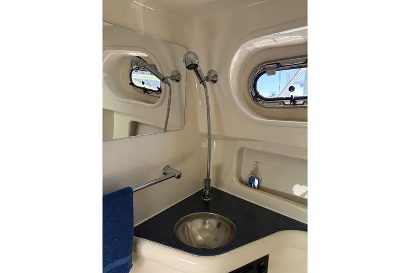 Slide: The Image of 2005 Pursuit 3370 Offshore boat bathroom with sink, shower, and porthole window. - 26