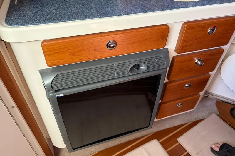 Slide: The Image of 2005 Pursuit 3370 Offshore boat interior with wooden cabinetry and built-in appliance. - 29