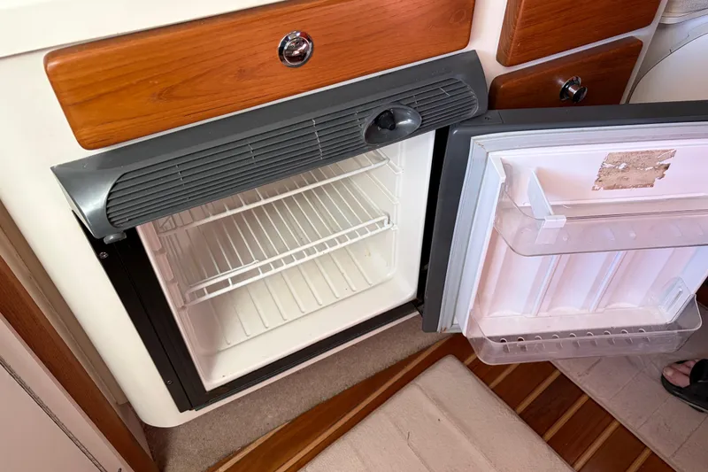 Slide: The Image of Open refrigerator inside a 2005 Pursuit 3370 Offshore boat, showing empty shelves. - 30