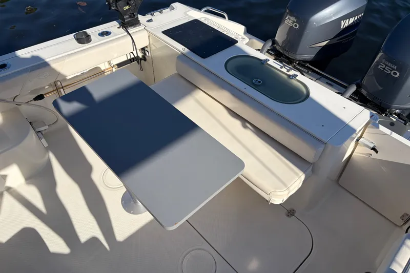 Slide: The Image of 2005 Pursuit 3370 Offshore boat interior with table, seating, and Yamaha engines. - 7