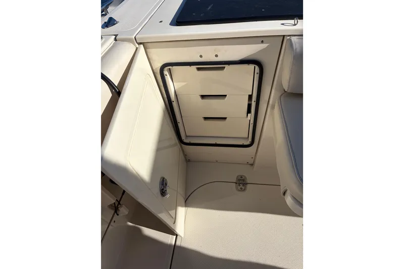 Slide: The Image of 2005 Pursuit 3370 Offshore boat interior storage compartment with open door and drawers. - 8