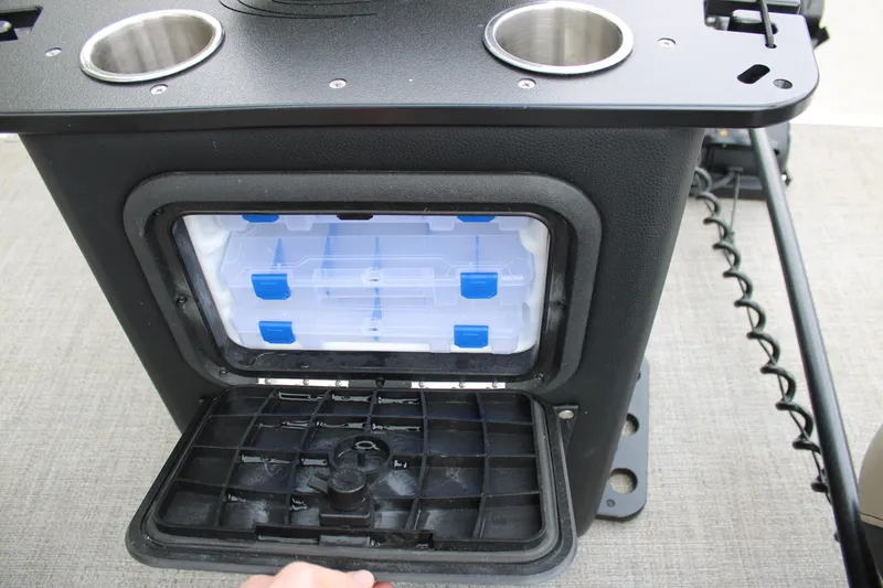 Slide: The Image of Storage compartment in a 2022 Baretta Cabrio C22CC boat, featuring cup holders and tackle boxes. - 13