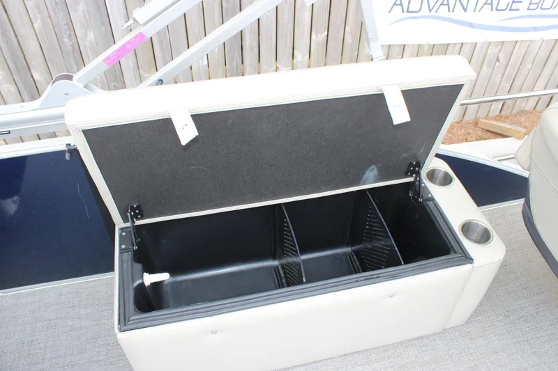 Slide: The Image of Open storage compartment on 2022 Baretta Cabrio C22CC boat with cup holders. - 16