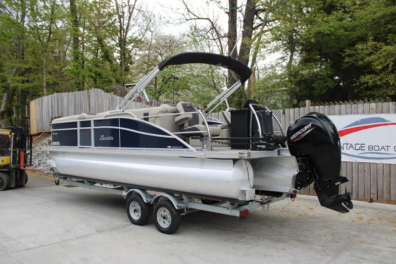 Slide: The Image of 2022 Baretta Cabrio C22CC pontoon boat on trailer, parked outdoors. - 2