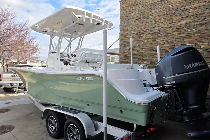 The Image of 2024 Sea Fox 248 Side Console boat with Yamaha engine on trailer, parked outdoors. - 0