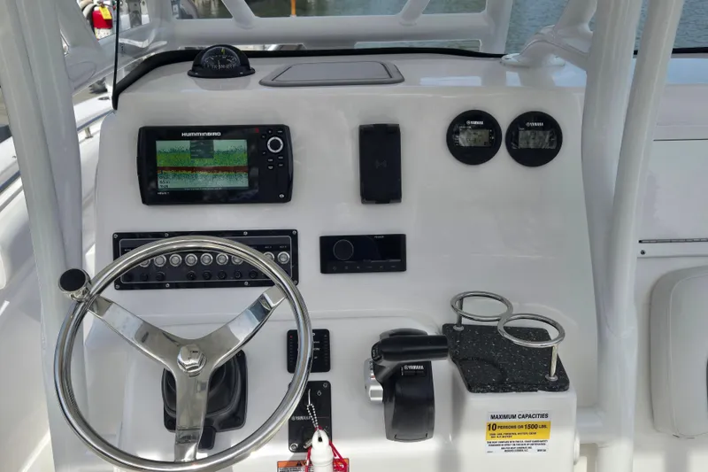 Slide: The Image of 2024 Sea Fox 248 Side Console boat with white cushioned seating on calm water. - 10