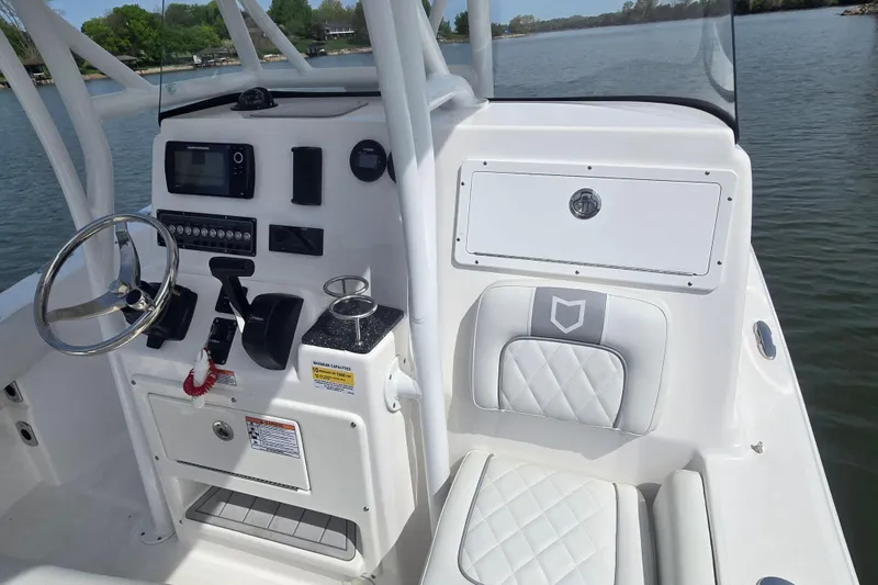 Slide: The Image of 2024 Sea Fox 248 Side Console boat on a serene lake with lush greenery. - 11