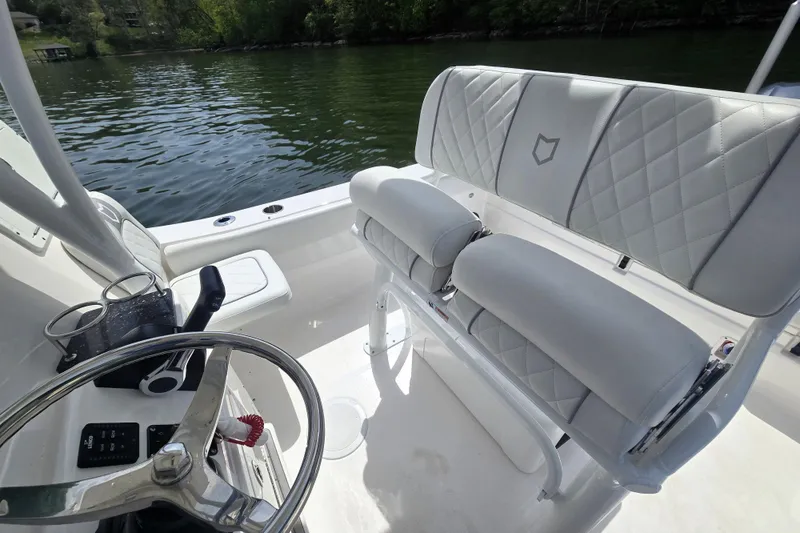 Slide: The Image of 2024 Sea Fox 248 Side Console boat interior with steering wheel and cushioned seating. - 19
