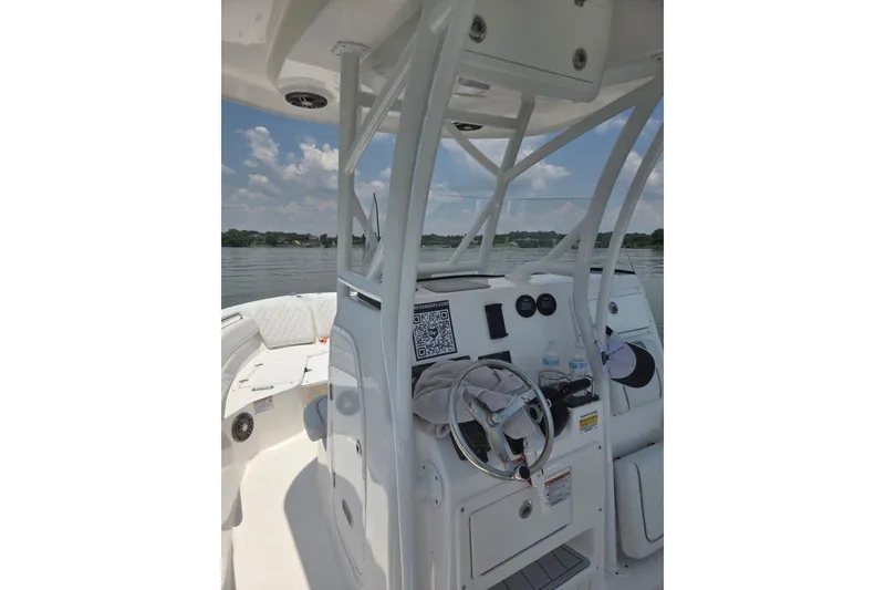 Slide: The Image of 2024 Seafox 248 Side Console boat interior with steering wheel and dashboard on a sunny day. - 2
