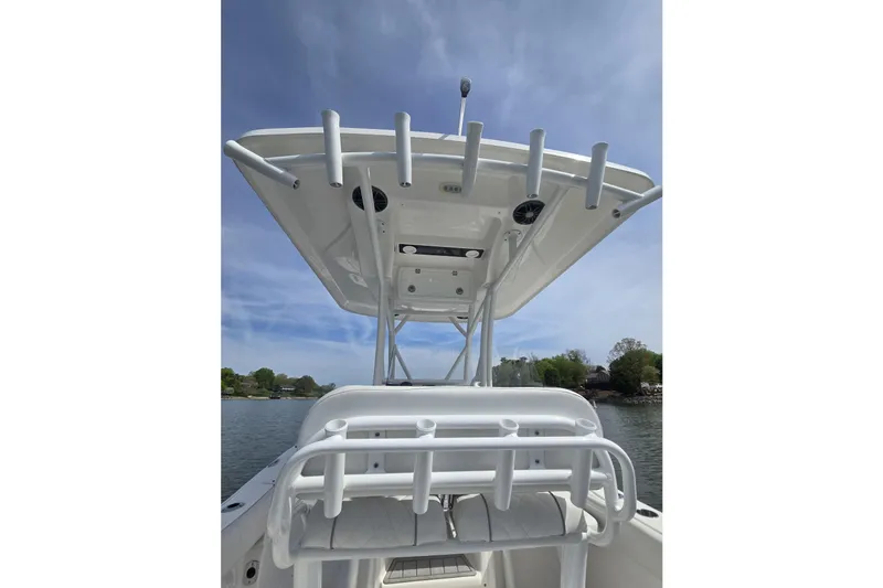 Slide: The Image of 2024 Sea Fox 248 Side Console boat with T-top and rod holders on a sunny day. - 21
