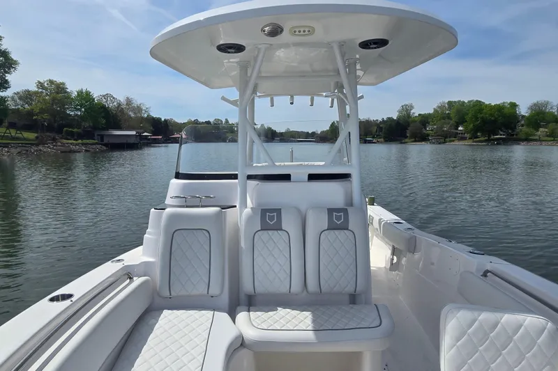 Slide: The Image of 2024 Sea Fox 248 Side Console boat cruising on a serene lake with lush greenery. - 5
