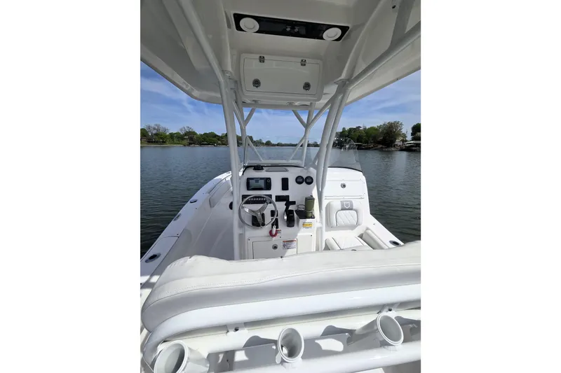 Slide: The Image of 2024 Sea Fox 248 Side Console boat on trailer, parked near a lake with trees. - 7