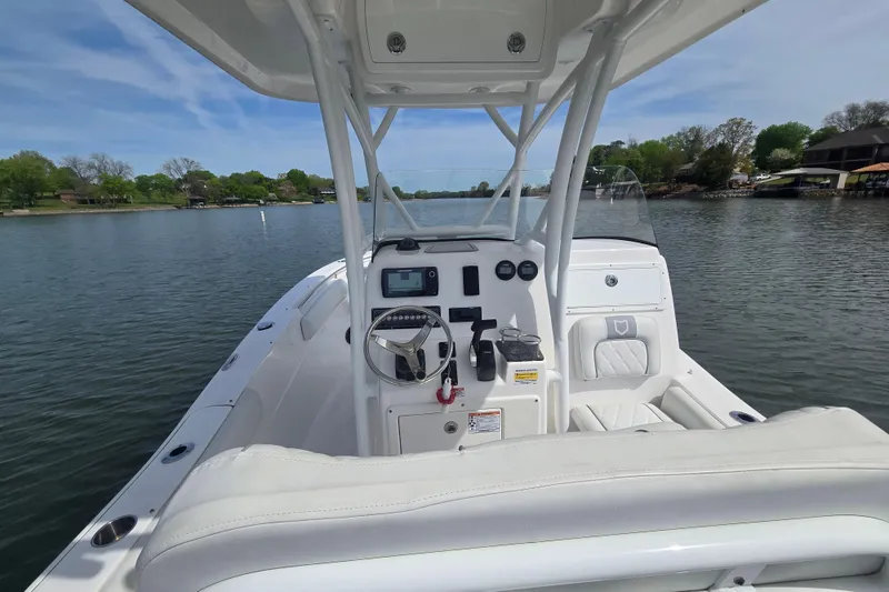 Slide: The Image of 2024 Seafox 248 Side Console boat on trailer, covered, with autumn trees in the background. - 8