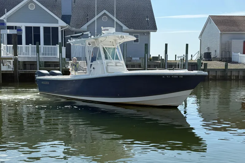 Slide: The Image of 2009 Regulator 26 Forward Seating boat docked near waterfront homes. - 0