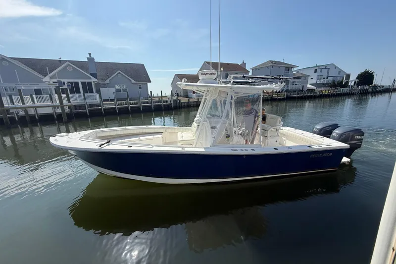 Slide: The Image of 2009 Regulator 26 Forward Seating boat on calm water near waterfront homes. - 1