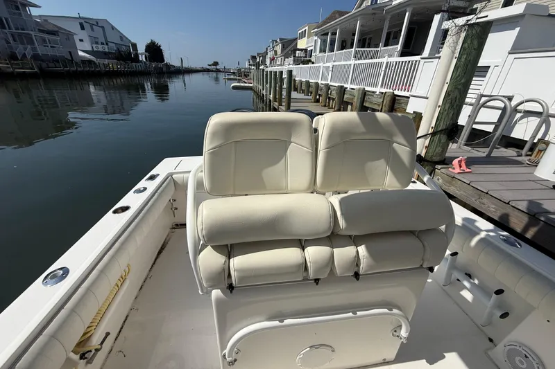 Slide: The Image of 2009 Regulator 26 Forward Seating boat docked by waterfront homes. - 11