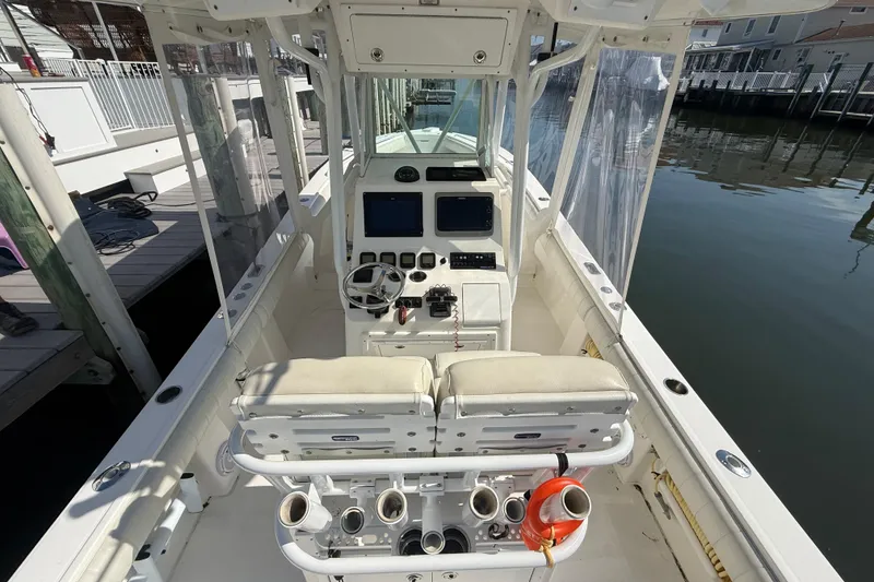 Slide: The Image of 2009 Regulator 26 Forward Seating boat interior with helm, seats, and fishing rod holders. - 12