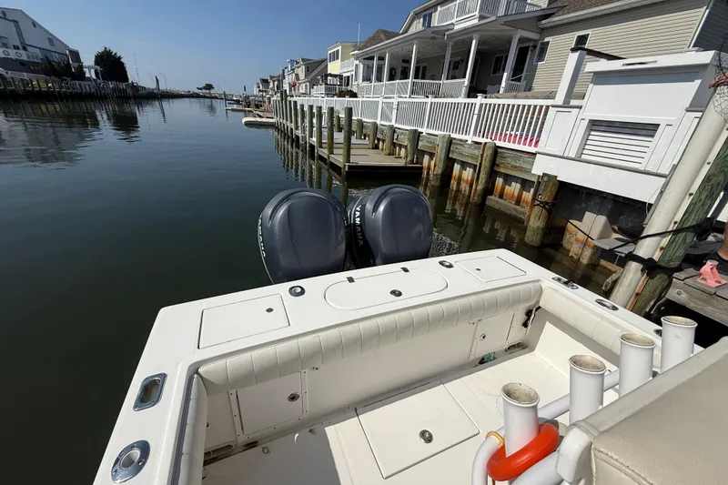 Slide: The Image of 2009 Regulator 26 Forward Seating boat docked by waterfront homes. - 13