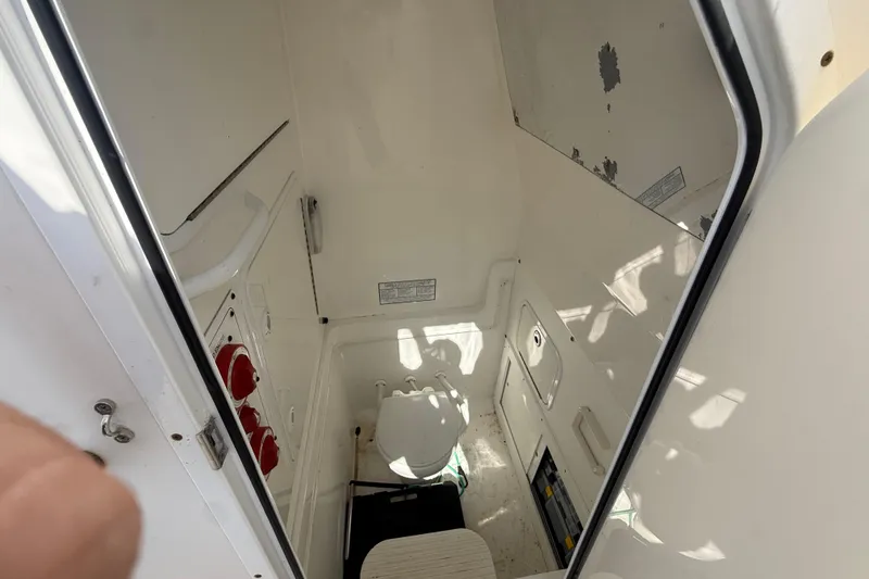 Slide: The Image of 2009 Regulator 26 Forward Seating boat interior with compact toilet and storage. - 15