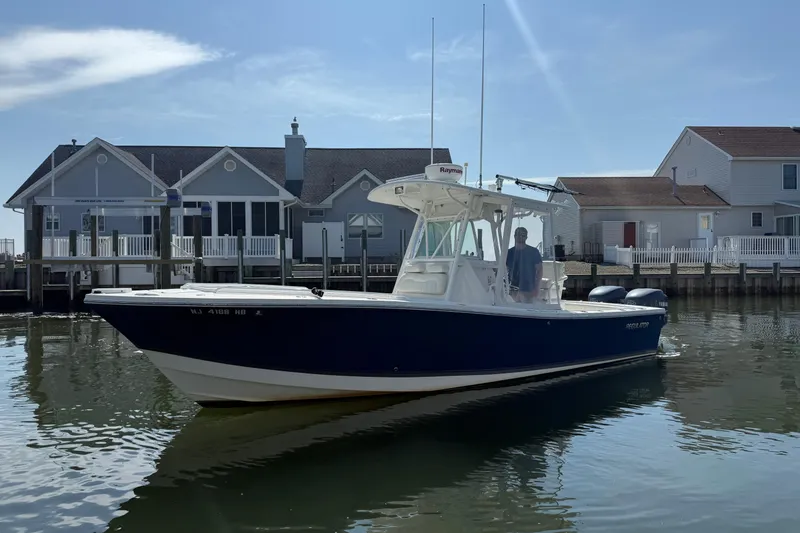 Slide: The Image of 2009 Regulator 26 Forward Seating boat docked near waterfront homes. - 16
