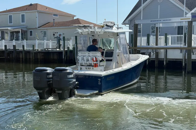 Slide: The Image of 2009 Regulator 26 Forward Seating boat with twin Yamaha engines near dockside homes. - 3