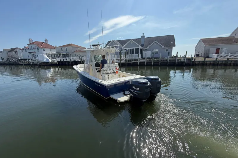 Slide: The Image of 2009 Regulator 26 Forward Seating boat cruising near waterfront homes. - 4