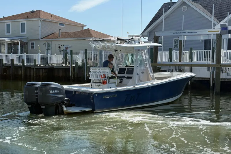 Slide: The Image of 2009 Regulator 26 Forward Seating boat with Yamaha engines in a marina setting. - 5