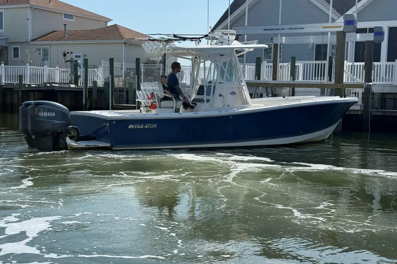 Slide: The Image of 2009 Regulator 26 Forward Seating boat with Yamaha engine docked near waterfront homes. - 7