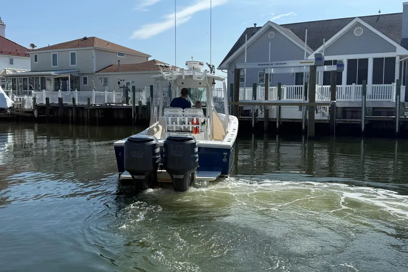 Slide: The Image of 2009 Regulator 26 Forward Seating boat navigating a residential canal with waterfront homes. - 8