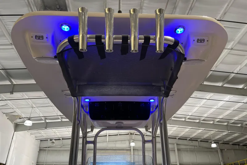 Slide: The Image of 2024 Key West 239 FS boat with blue LED lights and rod holders in a warehouse. - 20