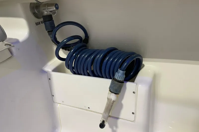 Slide: The Image of Coiled blue hose in 2024 Key West 239 FS boat's raw water washdown area. - 23