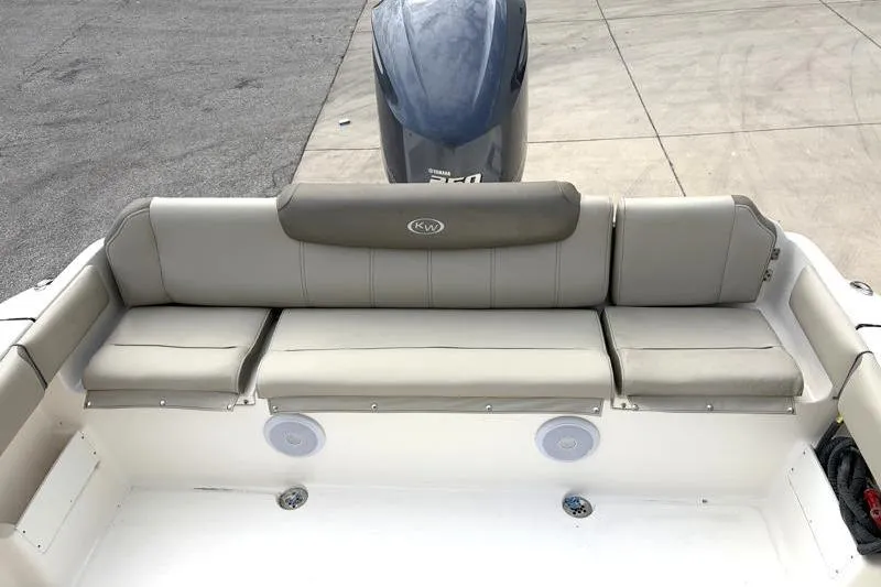 Slide: The Image of 2024 Key West 239 FS boat seating area with cushioned bench and motor view. - 34