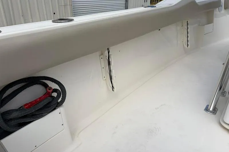 Slide: The Image of 2024 Key West 239 FS boat interior, featuring clean white deck and storage compartment. - 38