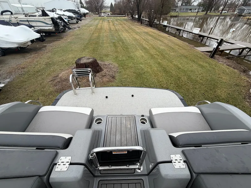 Slide: The Image of 2023 Tahoe WAKETOON boat by the shore with grass and dock. - 21