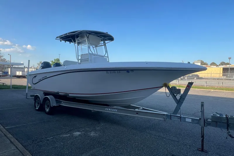 Slide: The Image of 2006 Fountain 23 Center Console boat on trailer, parked outdoors under clear blue sky. - 10