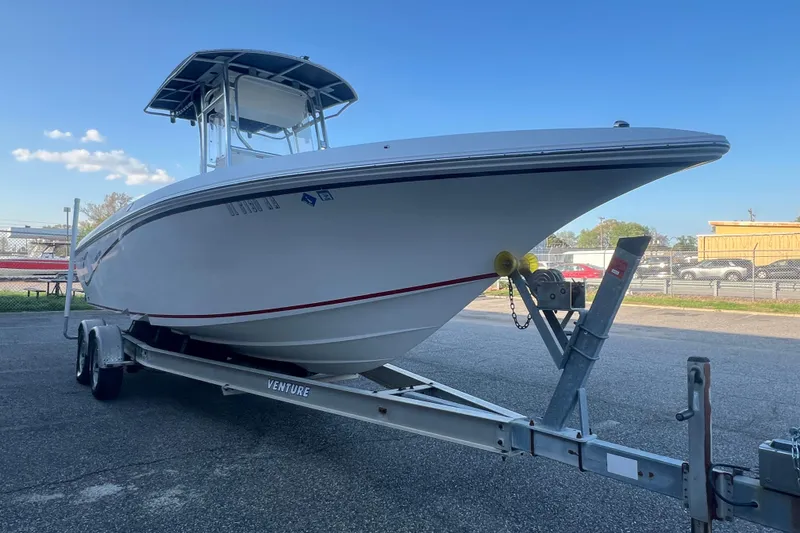 Slide: The Image of 2006 Fountain 23 Center Console boat on trailer, parked outdoors under clear blue sky. - 11
